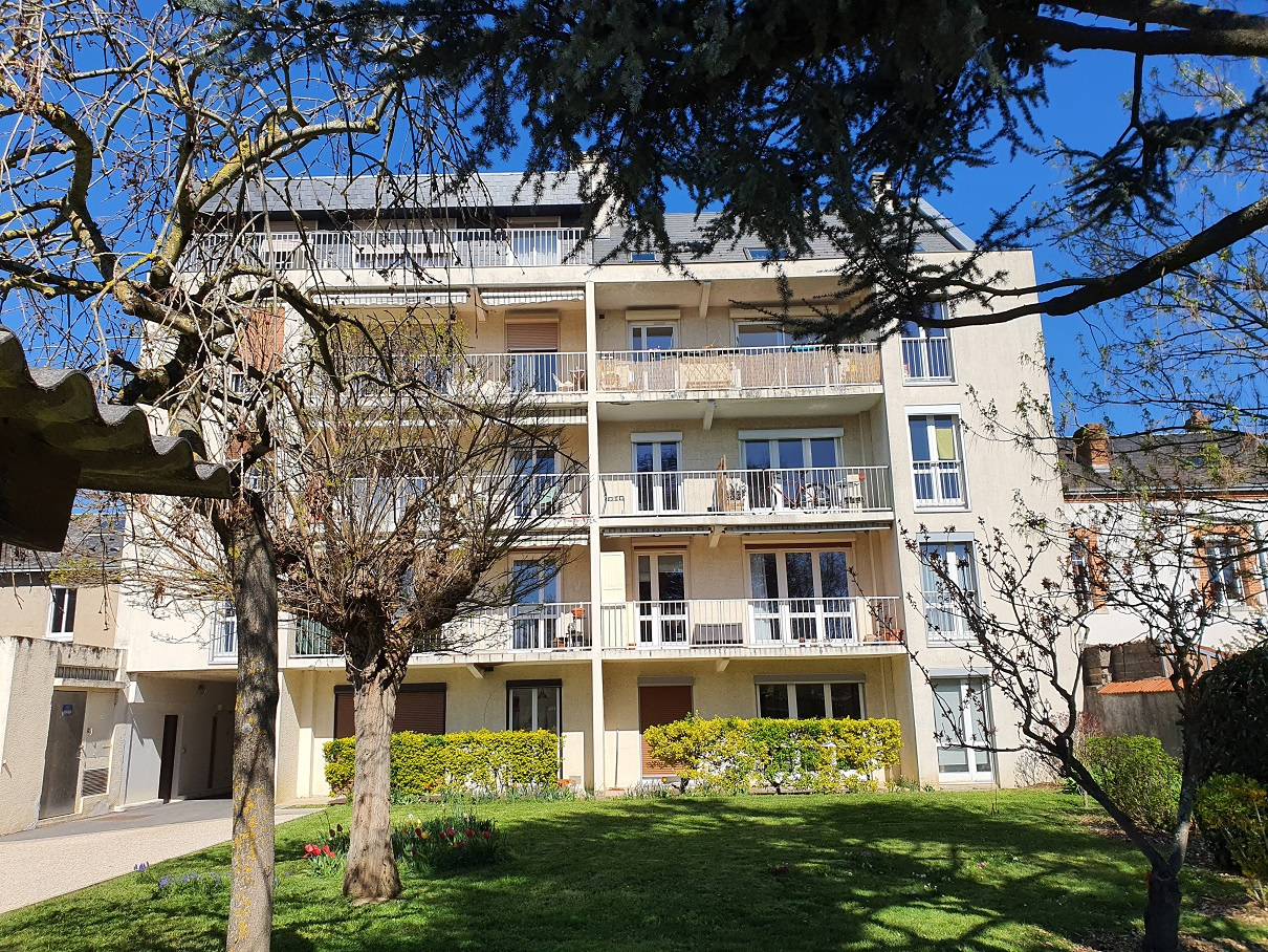 vue de la Façade arrière de l'immeuble donnant sur le jardin et les parkings